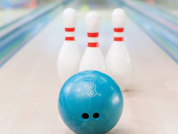 Three pins and bowling ball on bowling lane