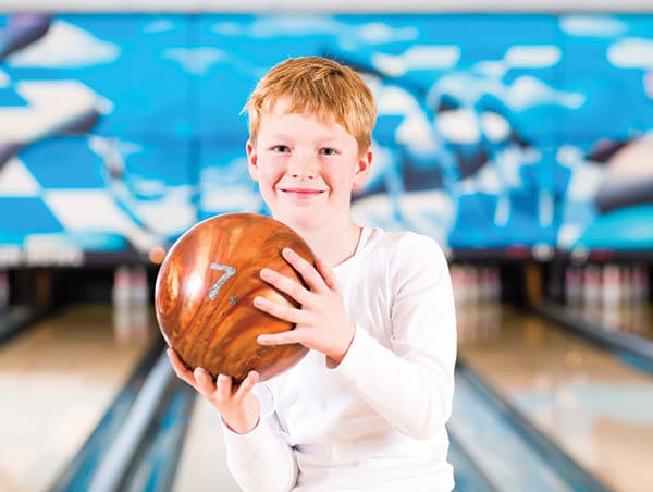 Young boy holding bowling ball