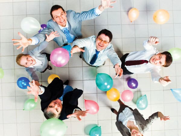 Employees celebrating by tossing balloons in the air